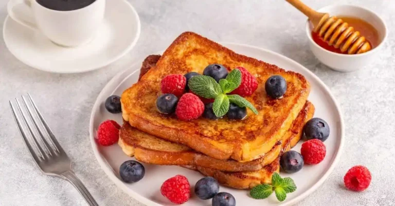 Golden brown French toast slices topped with fresh berries.