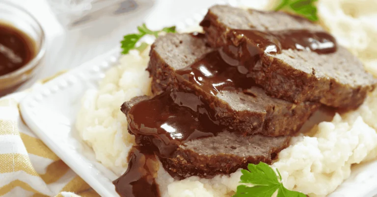 Easy Meatloaf Recipe served on a plate with a side of vegetables.