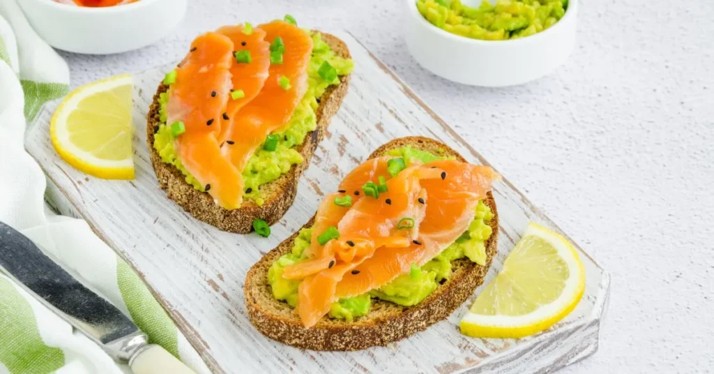 A delicious avocado toast topped with a sprinkle of salt, pepper, and red chili flakes on toasted bread.