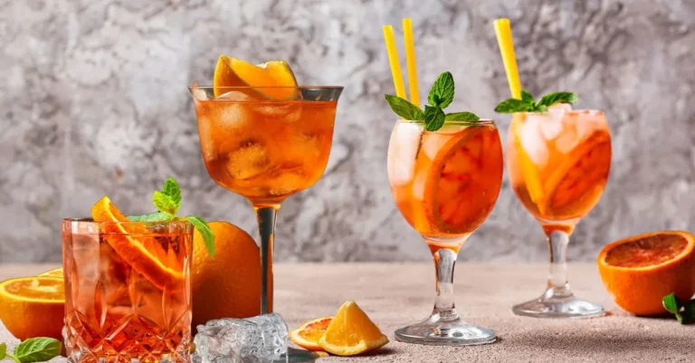 A glass of Classic Aperol Spritz with orange slices and ice cubes on a table.