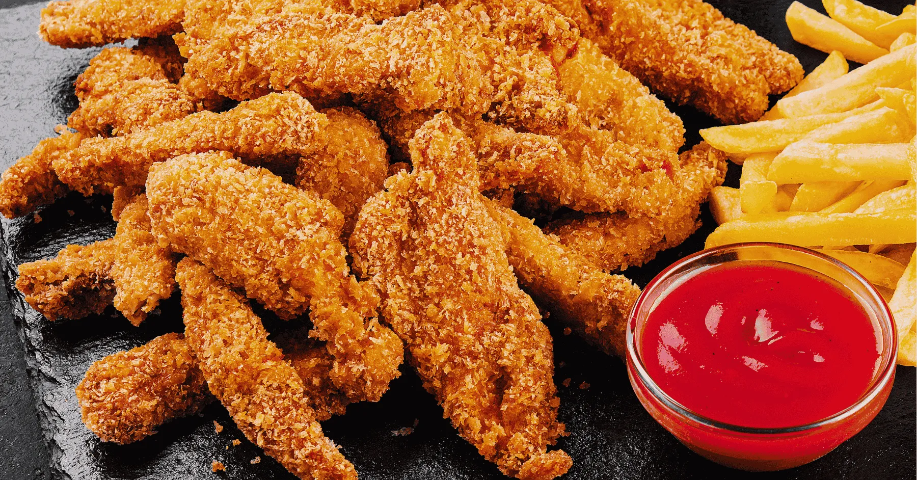 Golden brown homemade chicken nuggets served on a plate with dipping sauce.