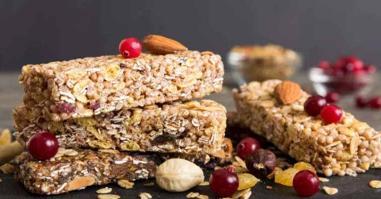 A bowl of homemade granola with oats, nuts, and dried fruit, served with a side of yogurt.