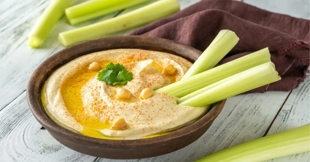 A vibrant plate of hummus served with a variety of dips, pita bread, and colorful vegetables, showcasing its versatility.