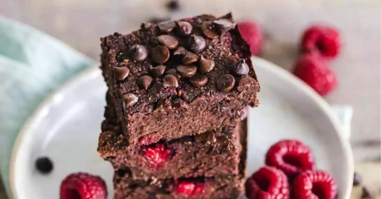 A plate of rich, fudgy chocolate brownies with a gooey center, topped with chocolate chips.