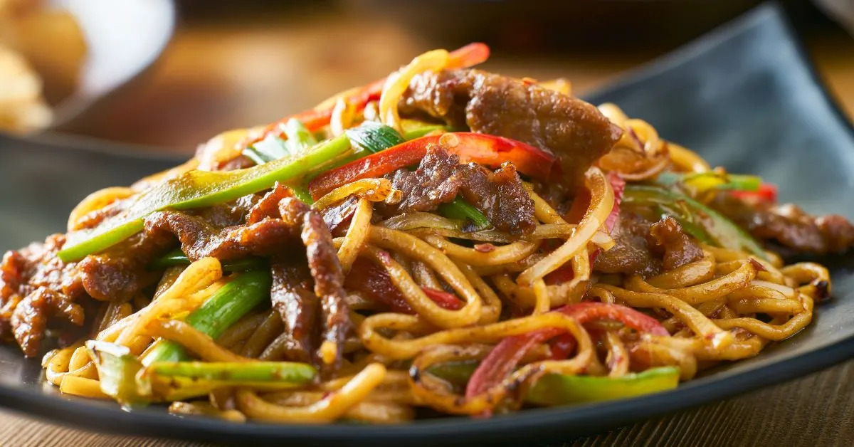 A plate of savory quick beef stir-fry with tender beef strips, colorful vegetables, and a glossy sauce.