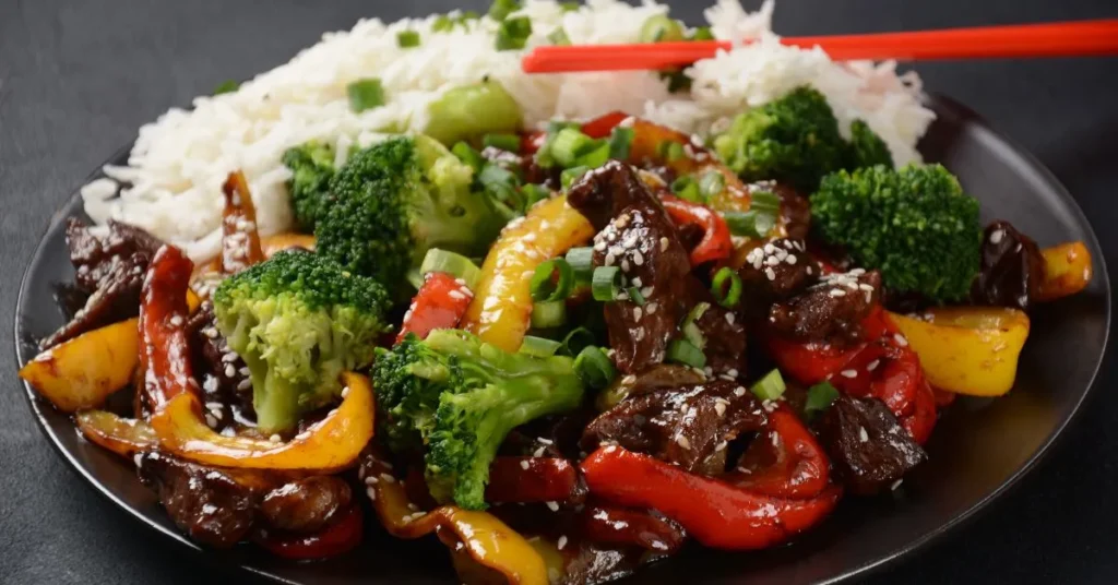 A sizzling pan of quick beef stir-fry with tender beef slices, bright vegetables, and a savory sauce being cooked.