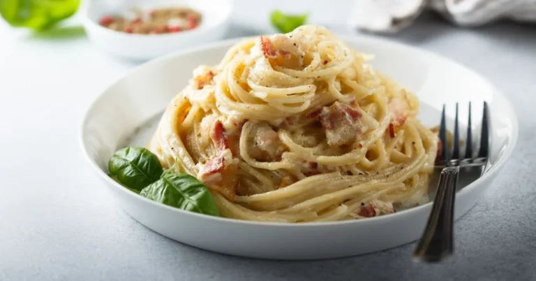 A plate of freshly cooked capellini pasta garnished with parmesan, herbs, and cherry tomatoes.