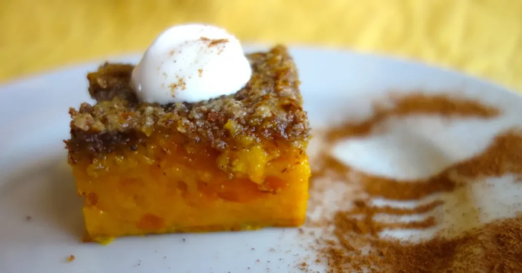 A golden, buttery dump cake with a crispy crust and gooey fruit filling, served on a plate with a scoop of ice cream.