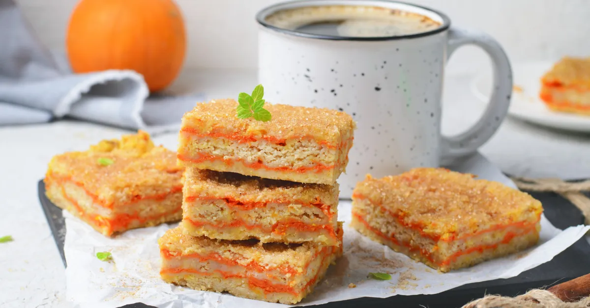 A delicious pumpkin dump cake topped with a golden crumbly crust, served on a plate with a dollop of whipped cream.