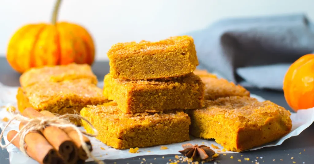 A warm and spiced pumpkin dump cake with a golden, buttery topping, served with a scoop of vanilla ice cream.