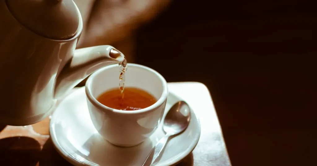 A box of Throat Coat Tea alongside a steaming cup, known for its soothing herbal properties.